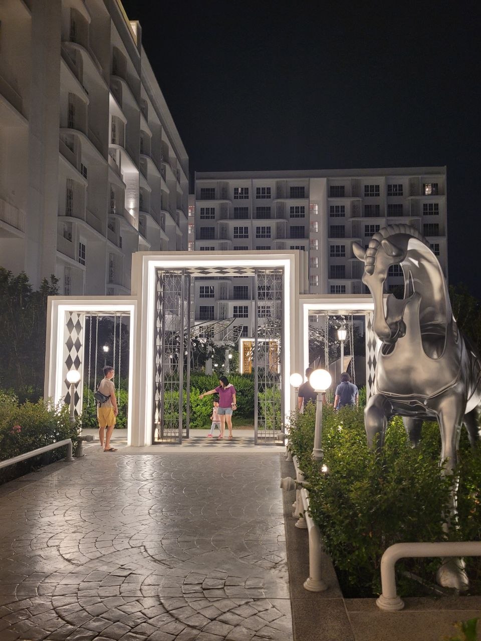 Illuminated entrance courtyard with horse sculpture