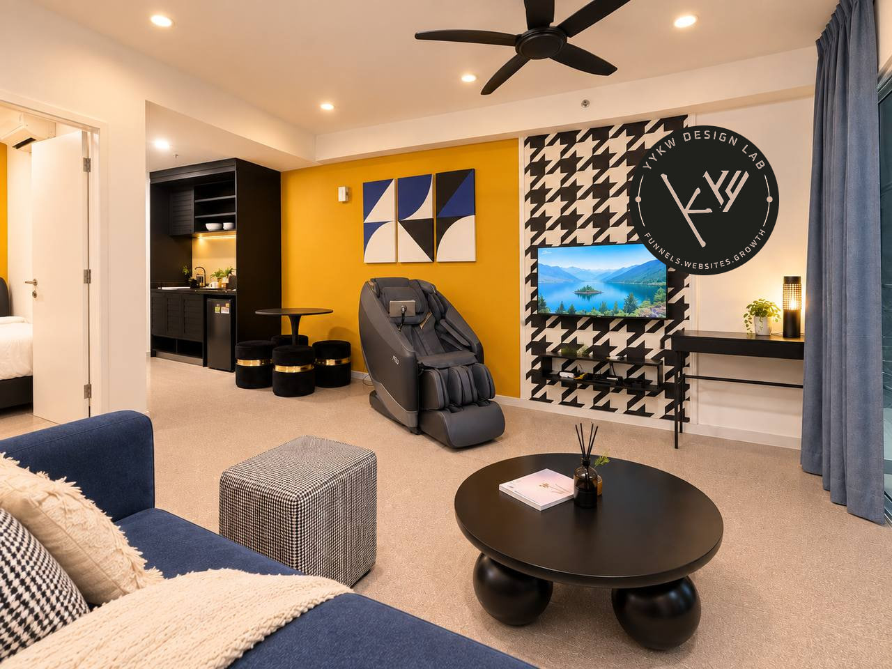 Living room with the in-unit massage chair, houndstooth TV wall, mustard accents and blue sofa