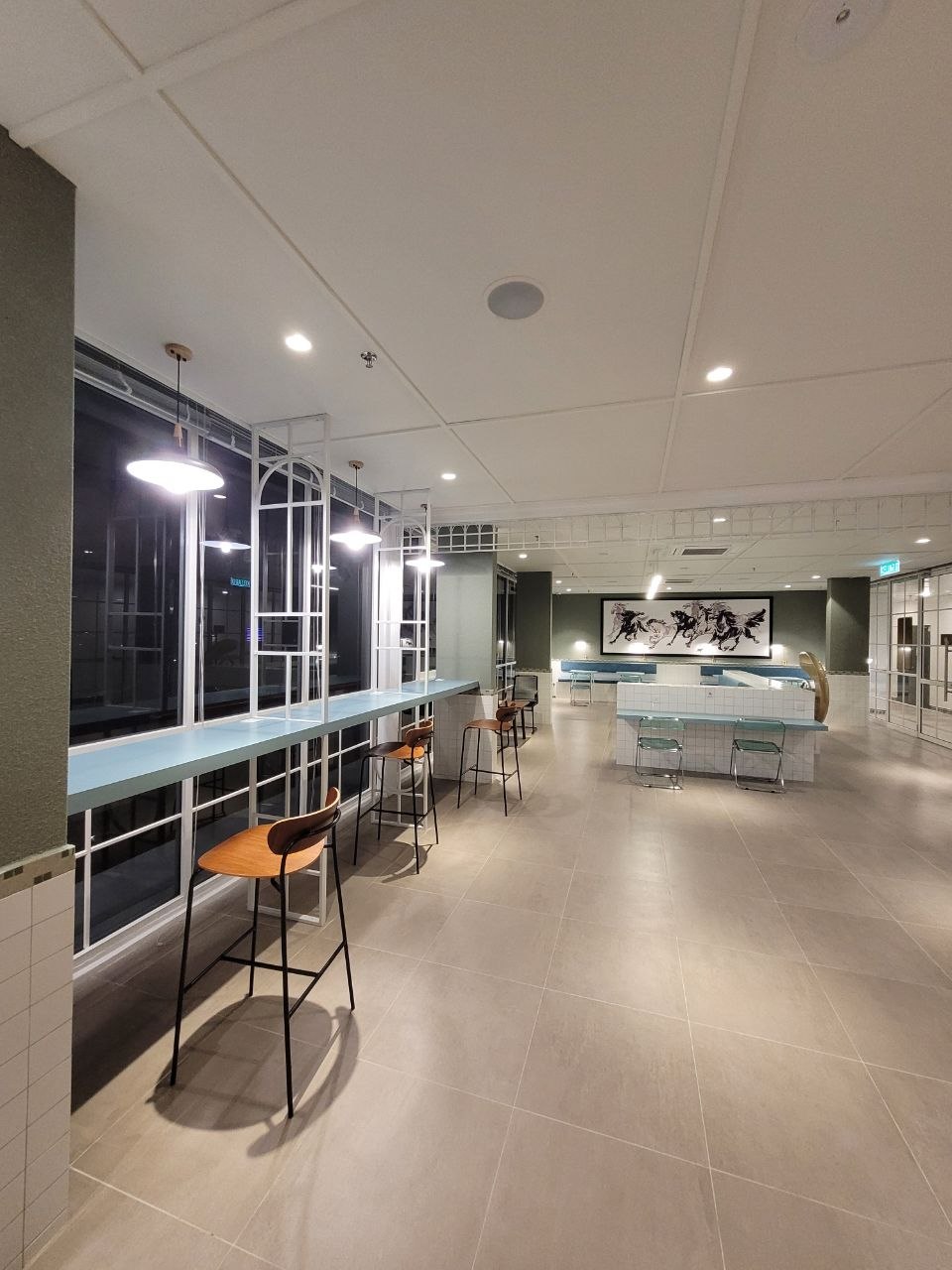 Communal lounge with bar seating and floor-to-ceiling city views