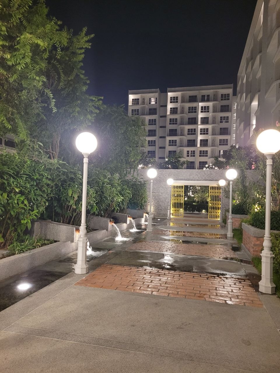 Lit garden walkway with cascading water features
