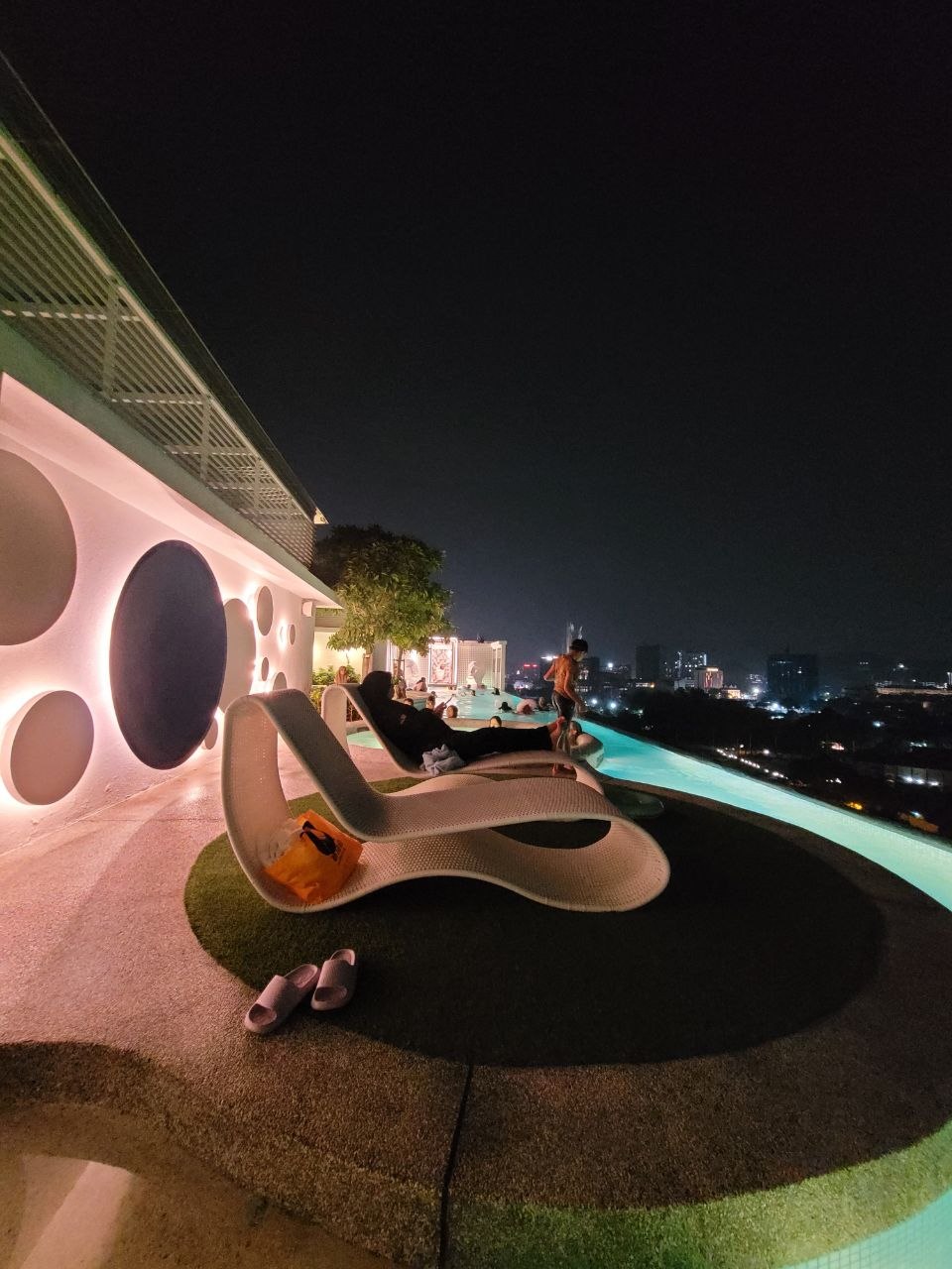 Loungers on the rooftop sky deck overlooking the Ipoh city skyline